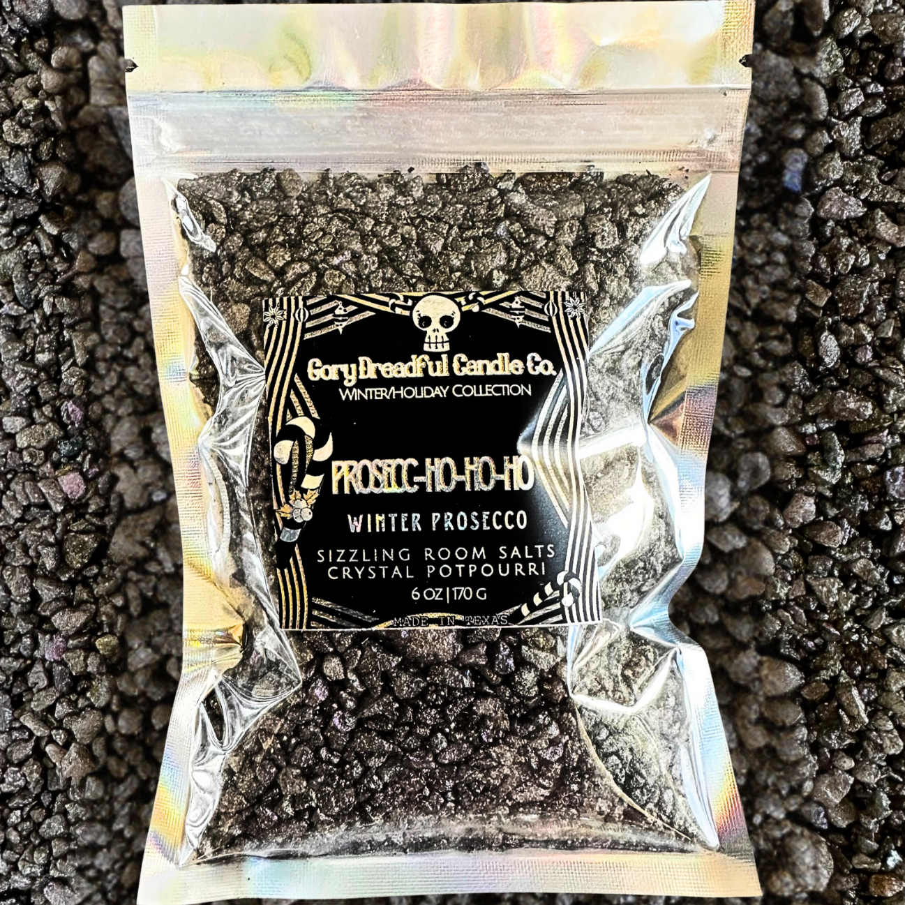 A sealed silver bag of Gory Dreadful Candle Co Prosecc-Ho-Ho-Ho Sizzling Room Salt Crystals with a holographic design and branding information on the label.