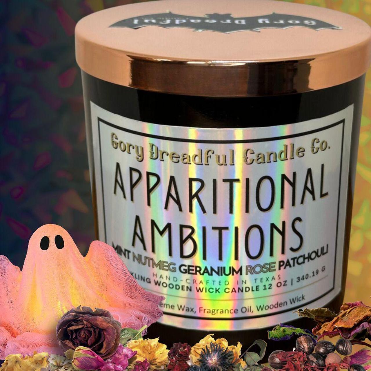 A jar candle from Gory Dreadful Candle Co. labeled 'Apparitional Ambitions,' shown with a metallic rose-gold lid and a white label.